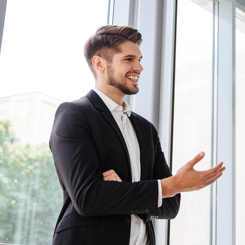 Two handsome young businessmen smiling and talking in office